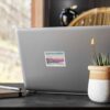 Modern laptop with a scenic travel photo sticker, desk setup, and indoor natural light.