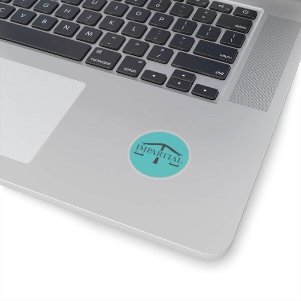 Ambiguous logo sticker on laptop with keyboard, representing impartiality and fairness.